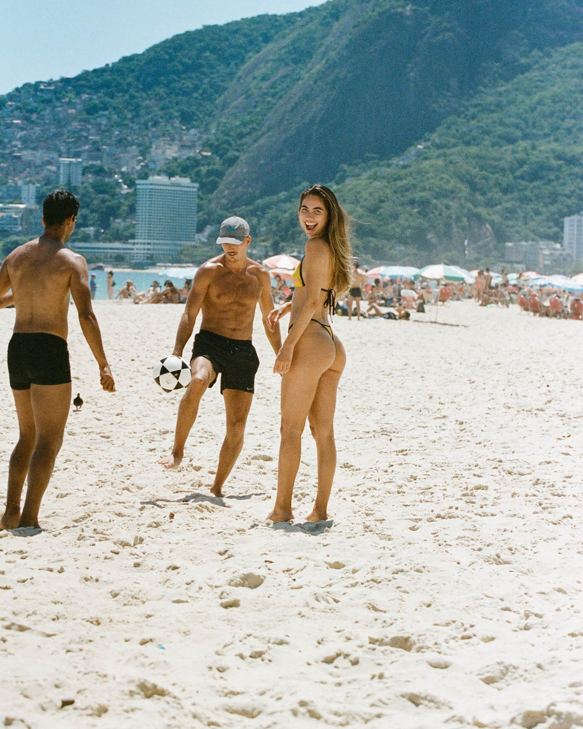Dazzling in a black, pink, and yellow graphic print triangle bikini with adjustable sides. The high-waisted thong design embodies summer bikini flair for a vibrant beach look.