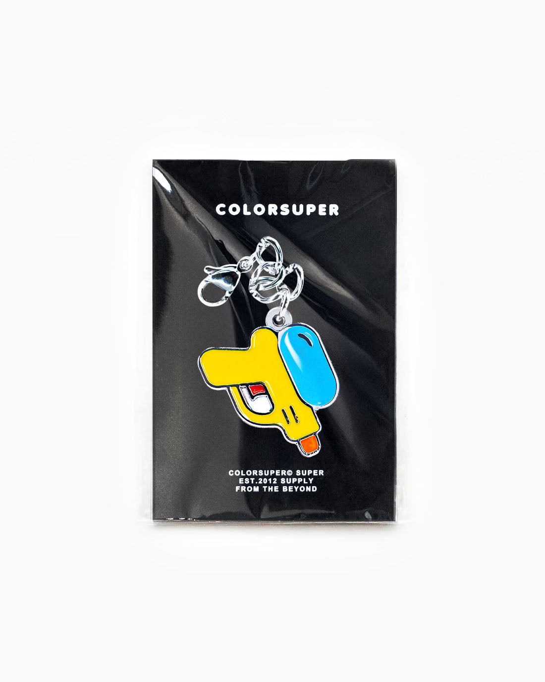 Bikini Charm - Squirter Charm featuring a colorful water gun design on a packaging background. - Alternate view
