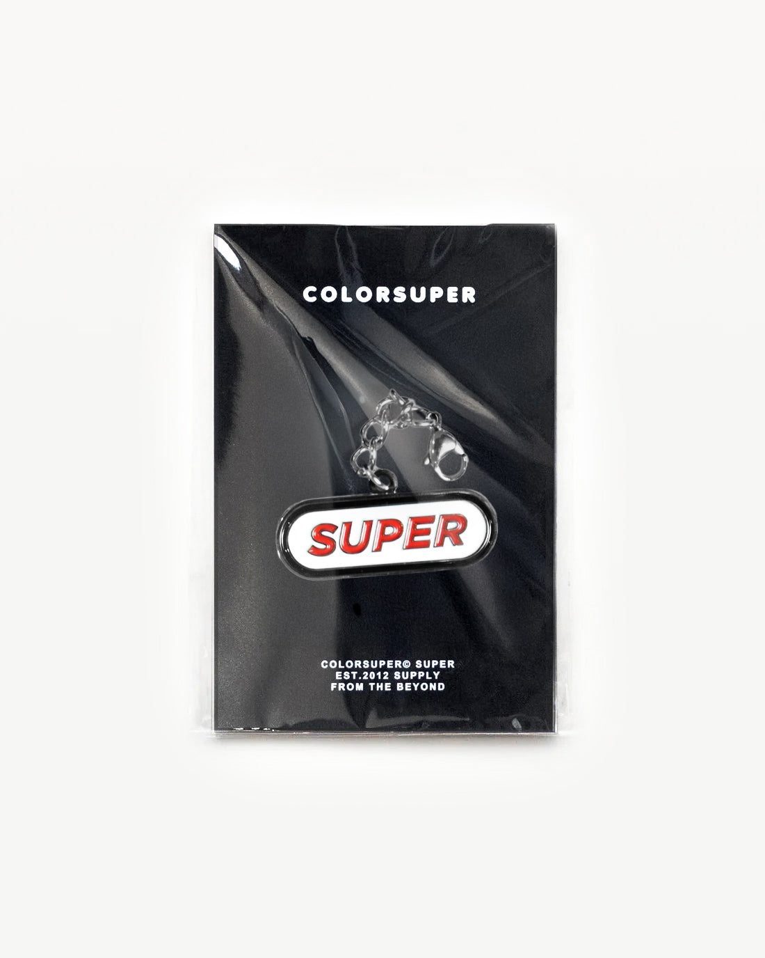 Colorsuper SUPER charm in packaging, featuring bold logo design and durable clip for classic style. - Alternate view