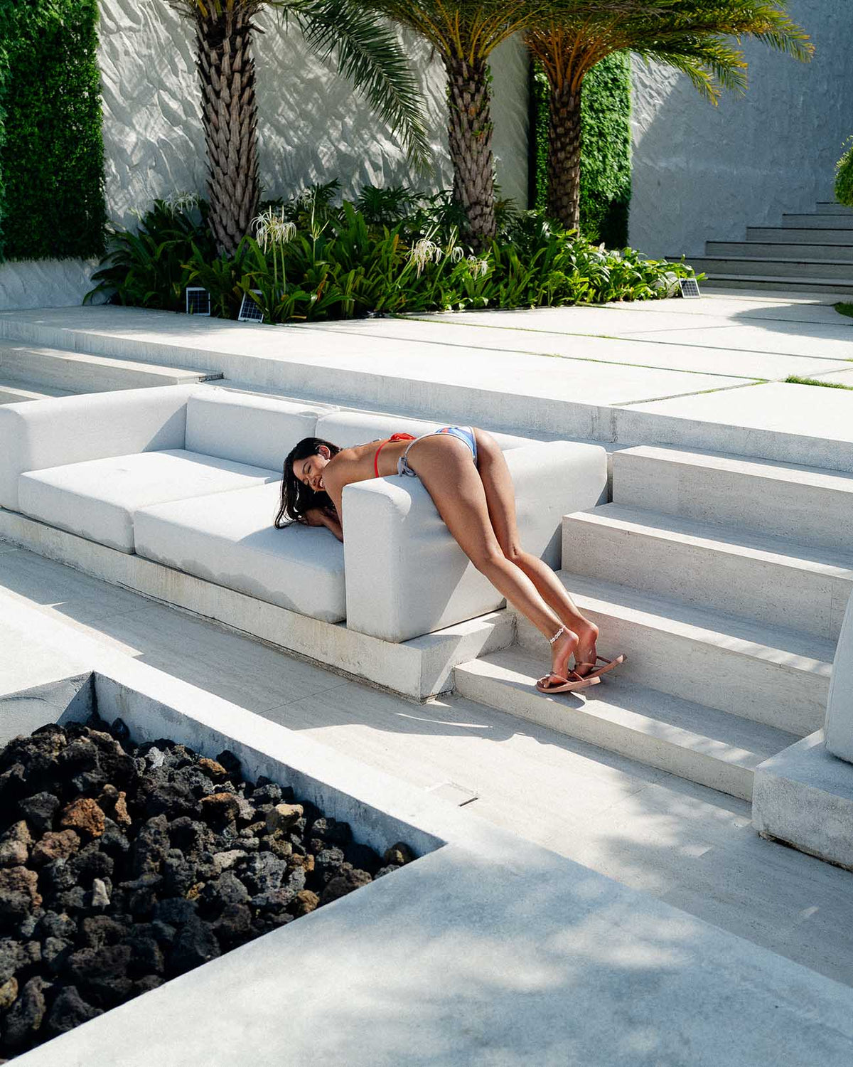 Model lounging in Moto Grey Brazilian bikini, showcasing modern swimwear design and vibrant swimwear style.